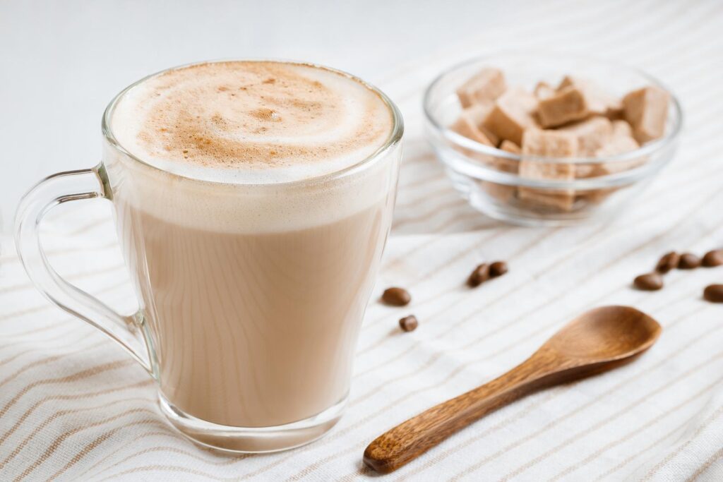 Latte coffee with foam on a light kitchen table