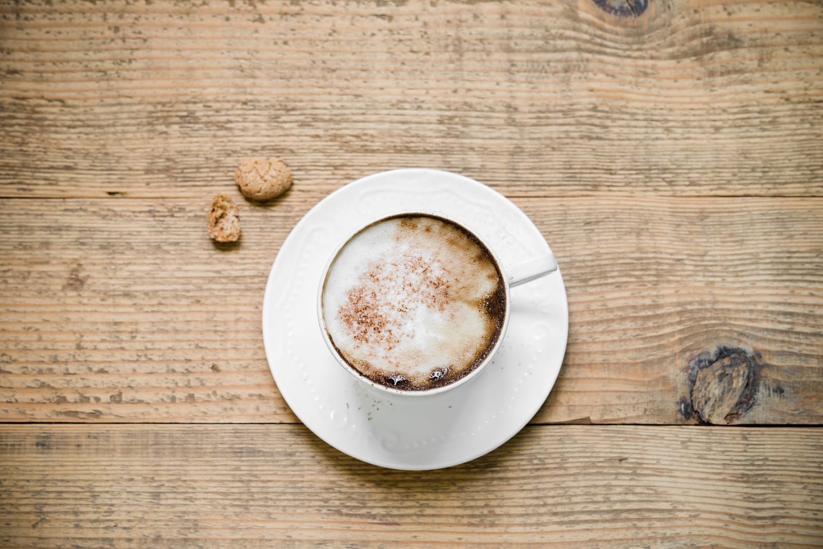 Cappuccino with biscotti on table